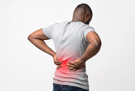 Black man holding his hands on lower back