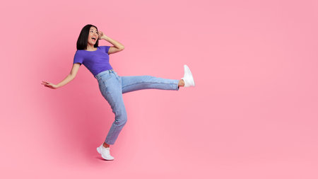 Happy young asian woman jumping at pink studio, copy space