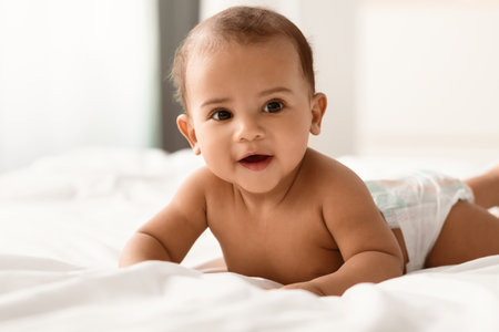 Cute adorable little African American kid lying on bed