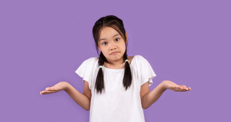 Clueless Korean Girl Shrugging Shoulders Standing Over Purple Studio Backgroundの写真素材