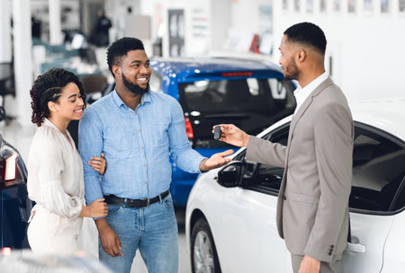 Afro Couple Taking Key From Manager In Car Rental Officeの写真素材