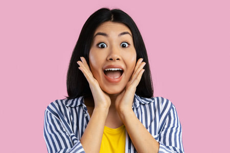 Close up portrait of shocked young asian woman screamingの写真素材