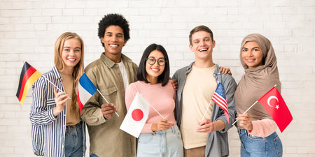Multiethnic young students with flags of different countries ready to studyの写真素材