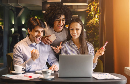 Successful business team looking at laptop happilyの写真素材