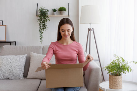 Happy young woman consumer opening package at home