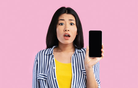 Asian woman showing blank smartphone screen for mockup