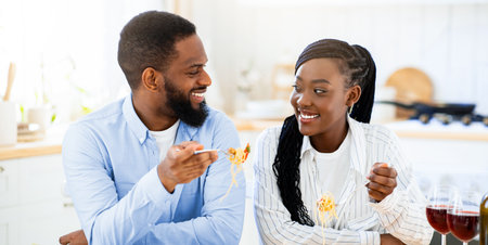Cheerful African American Lovers Having Romantic Lunch At Homeの写真素材