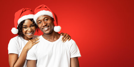 Cheerful black couple in love celebrating New Year togetherの写真素材