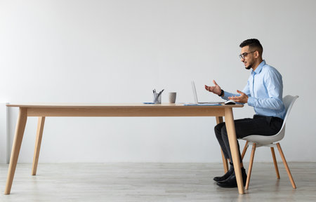 Arab man having video call using laptop and talkingの写真素材