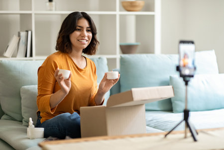 Beauty Blogging. Smiling Young Arab Female Influencer Recording Cosmetic Review At Homeの写真素材