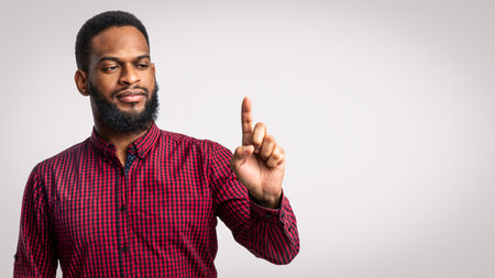African Man Looking At Finger Holding Invisible Object, Studio Shot