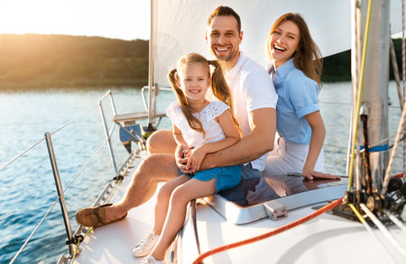 Happy Family Posing Sitting On Yacht Enjoying Sea Trip Outdoorsの写真素材