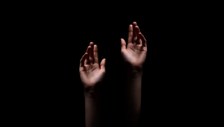 Two Hands Reaching Up in the Darkの写真素材