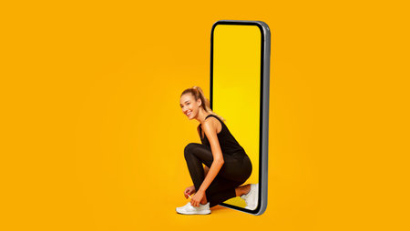 Sporty Female Lacing Shoes Near Big Cellphone Over Yellow Background