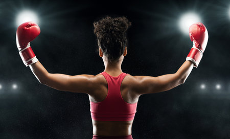 Back view of black woman boxer champion celebrating win