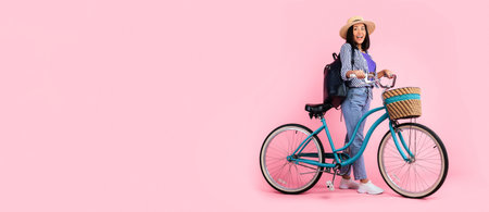 Excited asian woman standing with retro bicycle with wicker basketの写真素材