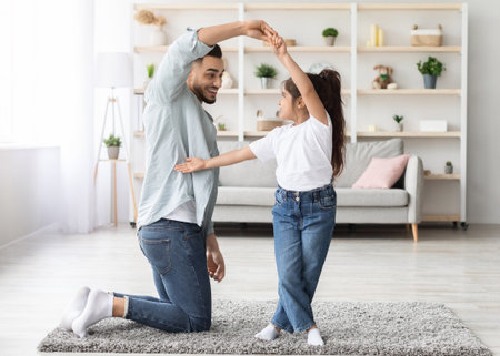Loving arabic father dancing with his little daughterの写真素材