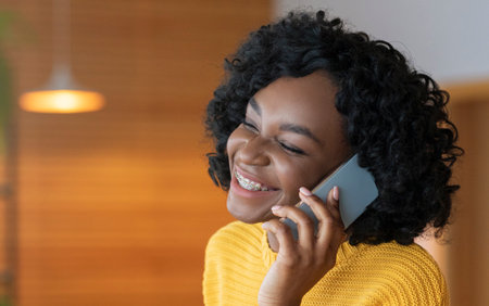 Close up of young afro woman talking by modern smartphone