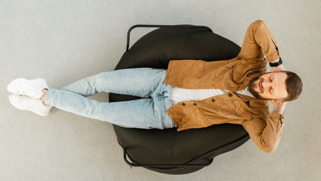 Happy Guy Relaxing With Eyes Closed In Chair At Homeの写真素材