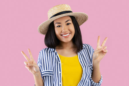 Asian woman showing two victory sign or peace gesture