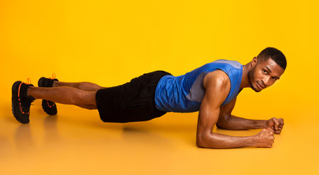 Afro man doing plank exercise or push ups