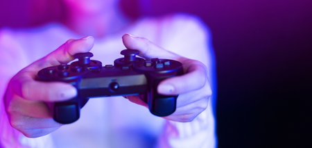 Woman Holding Video Game Controller in Front of Purple Lightの写真素材