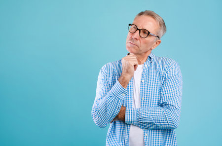 Portrait of pensive mature man looking up at studioの写真素材