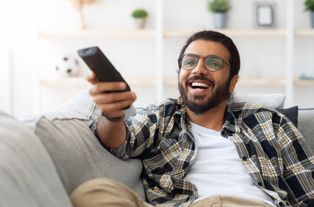 Relaxed arab guy wathcing movie on TVの写真素材