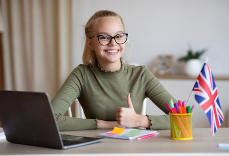 Cheerful girl with flag of Great Britain showing thumb upの写真素材