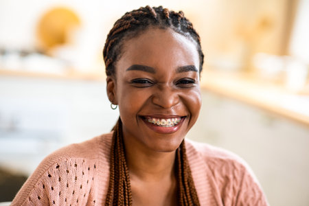 Beautiful Cheerful Black Woman With Braids And Dental Braces Posing In Kitchen