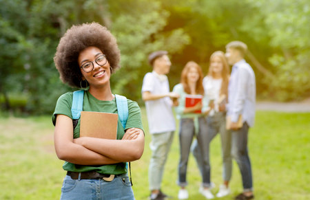 Student Life. Smiling black girl posing in front her college friends at campus