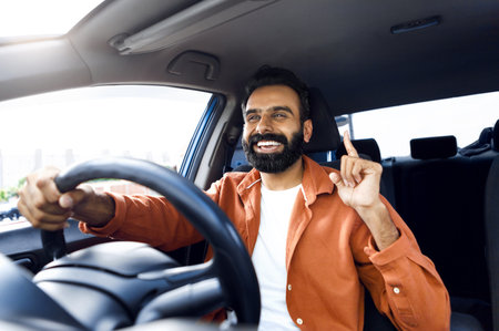 Cheerful Indian Man Riding Car And Singing Sitting Inside Vehicleの写真素材