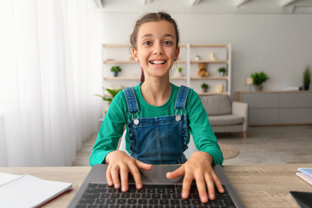 Girl sitting at table using laptop, webcam pov