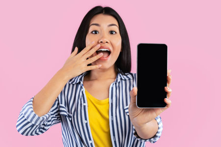 Asian woman showing blank smartphone screen for mockupの写真素材