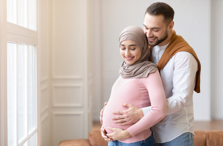 Muslim Couple Waiting For A Baby, Embracing Standing At Homeの写真素材