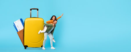 Couple enjoying summer vacation with luggage and booking mobile applicationの写真素材