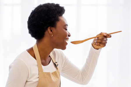 Black Housewife Cooking Preparing Healthy Dinner Tasting Meal In Kitchen