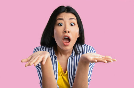 Surprised young asian woman staring at cameraの写真素材