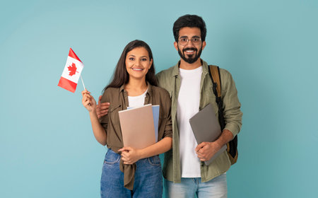 Cheerful multicultural man and woman with Canadian flag, blue background