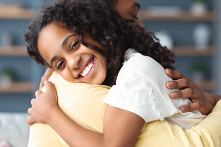Closeup portrait of happy african american father and daughter embracingの写真素材