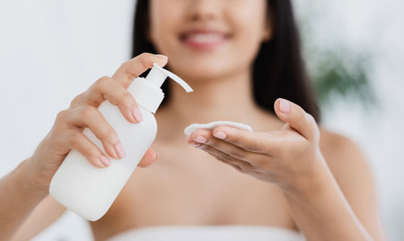 Closeup of asian girl applying cleansing lotion on cotton padの写真素材