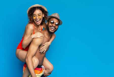 Happy black girl piggybacking with her boyfriendの写真素材