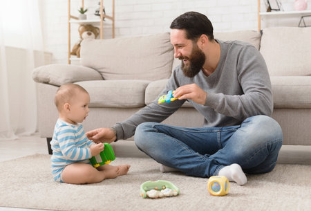 Young father and his baby boy playing with toy carの写真素材