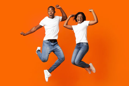 Happy black man and woman celebrating success, full length photo