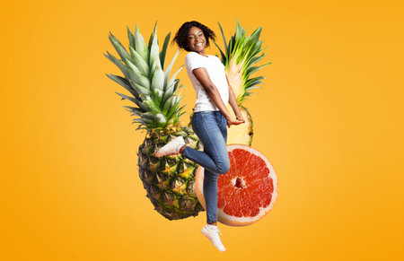 Joyful woman jumping amidst vibrant fruits in a bright settingの写真素材