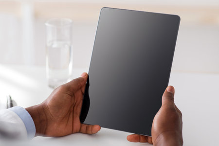 Doctor advice and technology for treat. African american doctor using digital tablet with black blank screen, mockup for adの写真素材
