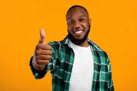 Positive African American Guy Gesturing Thumbs Up, Studio Shotの写真素材