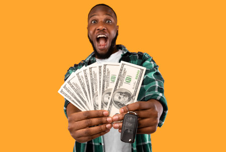 Excited African American Guy Showing Money Posing Over Yellow Backgroundの写真素材