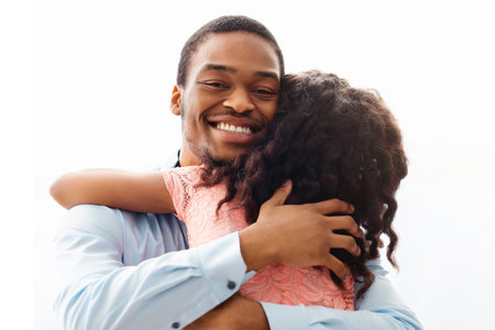 Happy black father and daughter hugging over whiteの写真素材