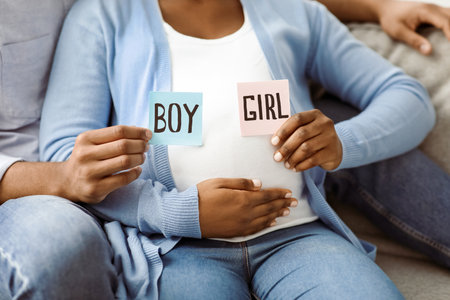 Pregnant family holding color cards for baby boy or girl, croppedの写真素材